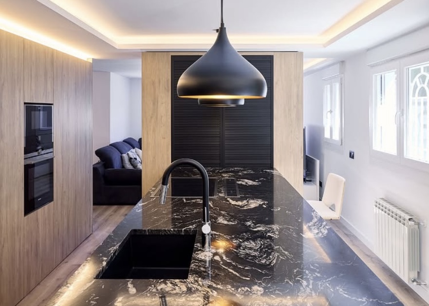 Cuisine fonctionnelle avec îlot central et grand plan de travail minéral, pensée pour un usage quotidien fluide